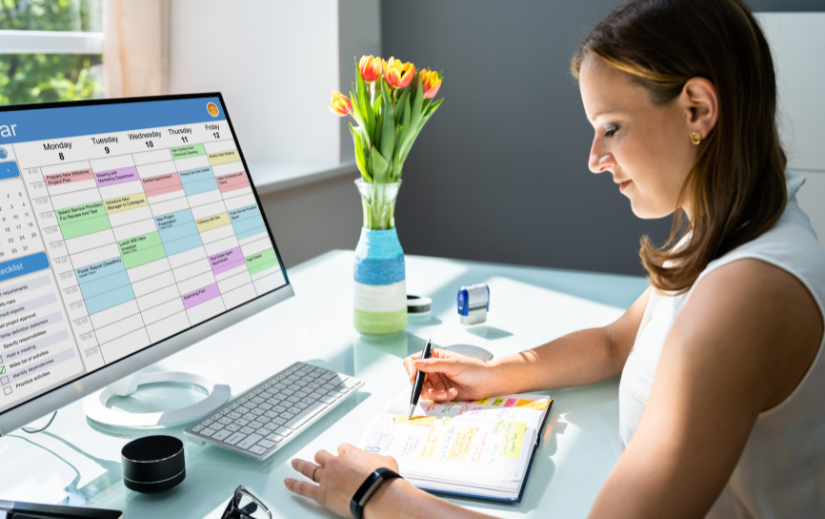 Woman organizing her schedule with a digital calendar and planner, focusing on online presence strategies.